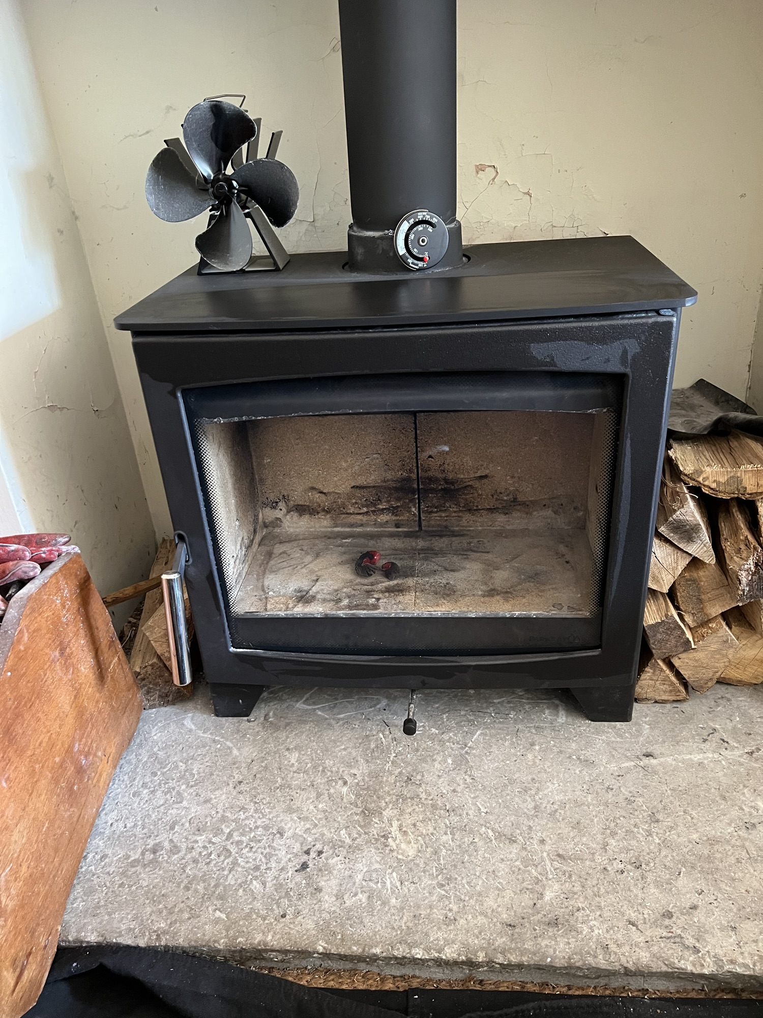 A multi-fuel stove being swept, with protective sheeting and rods